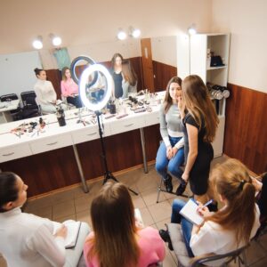 woman teaching make to a class of beauty students