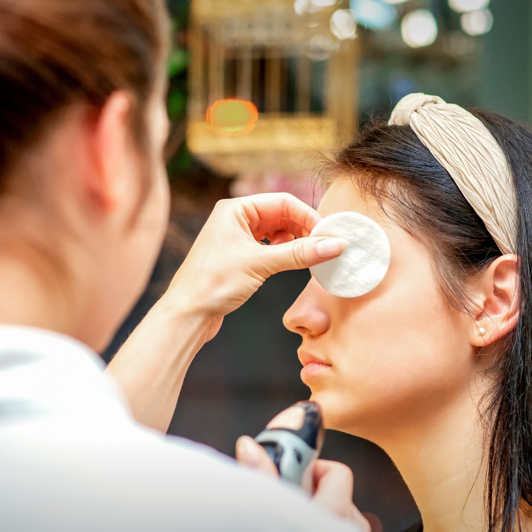 esthetician applying airbrush makeup