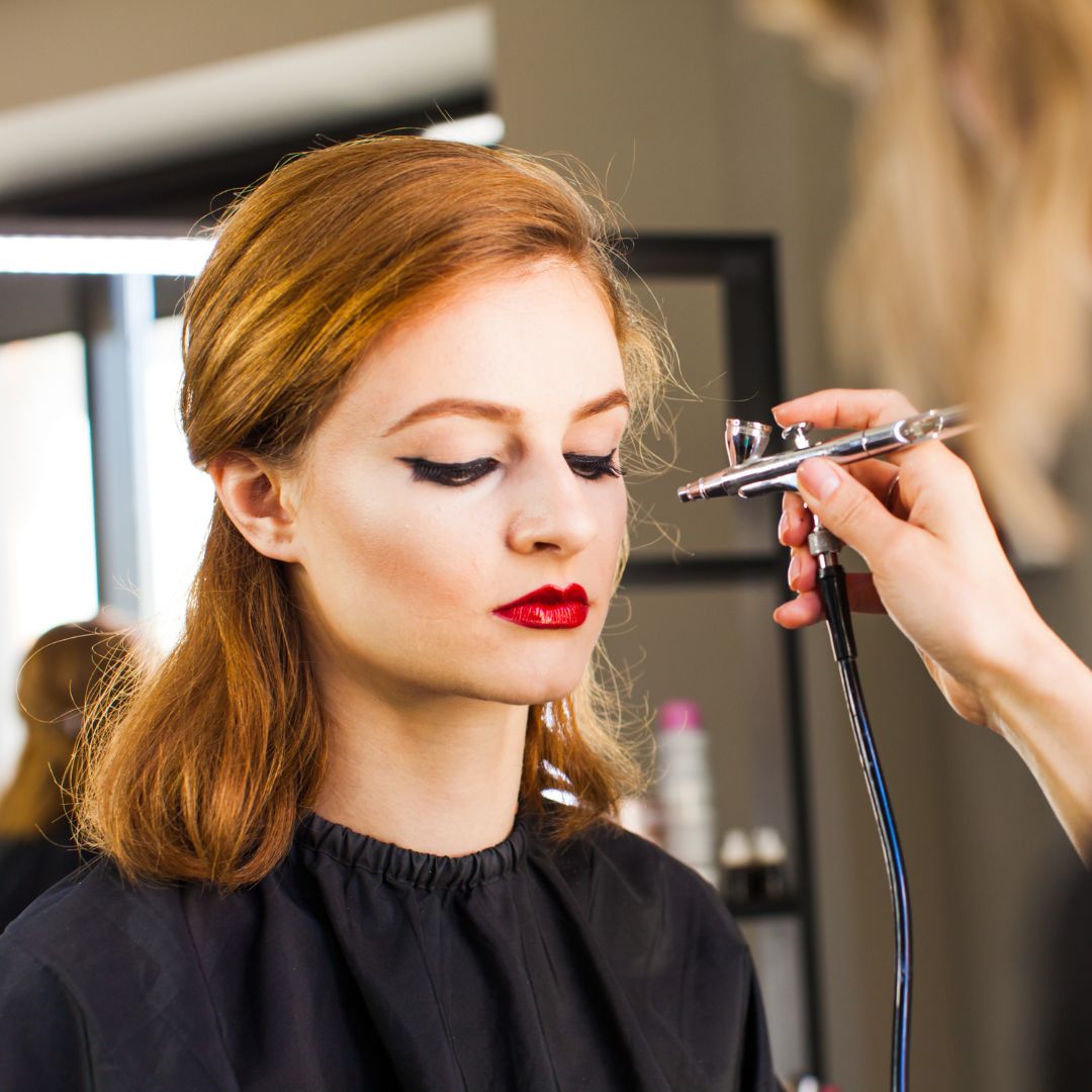 Woman having airbrush makeup applied. 